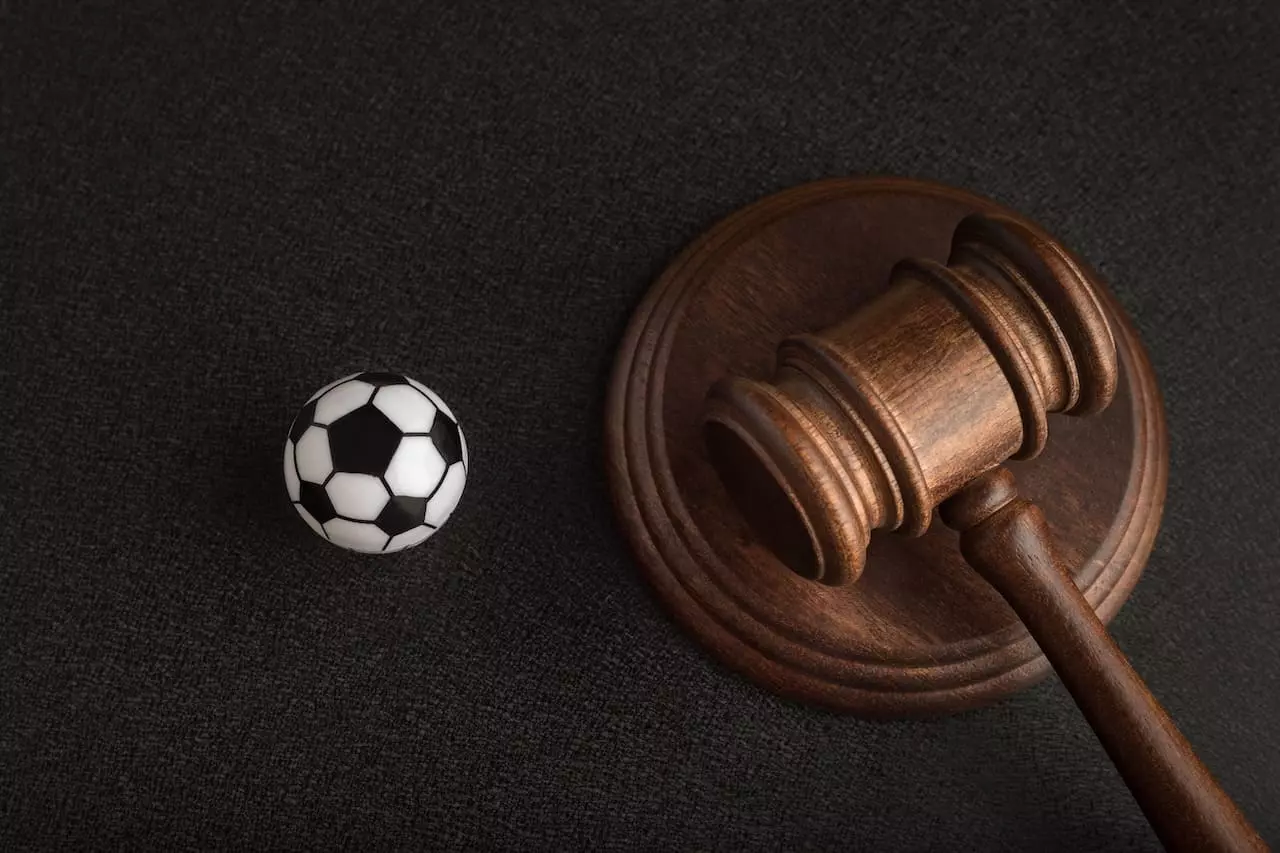 Marteau de president et ballon de football symbolisant les lois sur les paris sportifs 2024